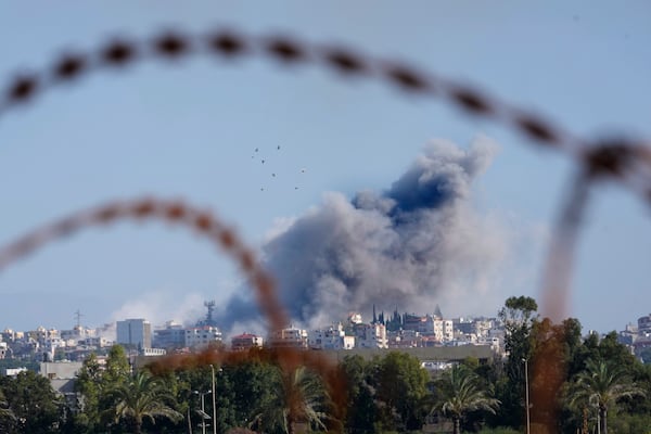 Smoke rises between buildings hit in an Israeli airstrike in Burj al-Shamali village, as it is seen from Tyre city, south Lebanon, Friday, Nov. 22, 2024. (AP Photo/Hussein Malla)