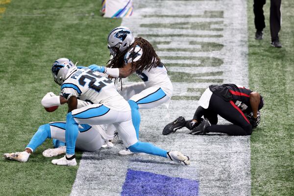 Panthers safety Juston Burris (left) celebrates with teammates cornerback Troy Pride Jr. (25) and safety Tre Boston after intercepting a pass intended for Falcons wide receiver Russell Gage (83, right) in the fourth quarter Sunday, Oct. 11, 2020, at Mercedes-Benz Stadium in Atlanta. The Falcons lost 23-16 to go 0-5 on the season. (Jason Getz/For the AJC)