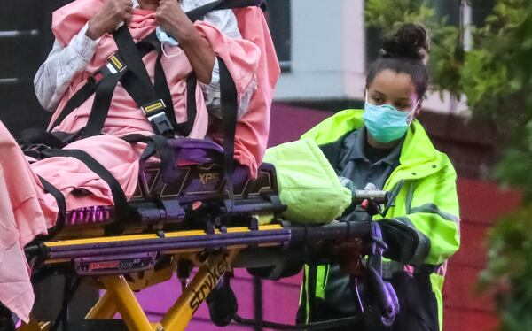 Grady ambulance crews wear masks and protective clothing like this emergency medical services worker does on Thursday, April 23, 2020, during a call on Wilbur Avenue in Atlanta. (JOHN SPINK/JSPINK@AJC.COM)