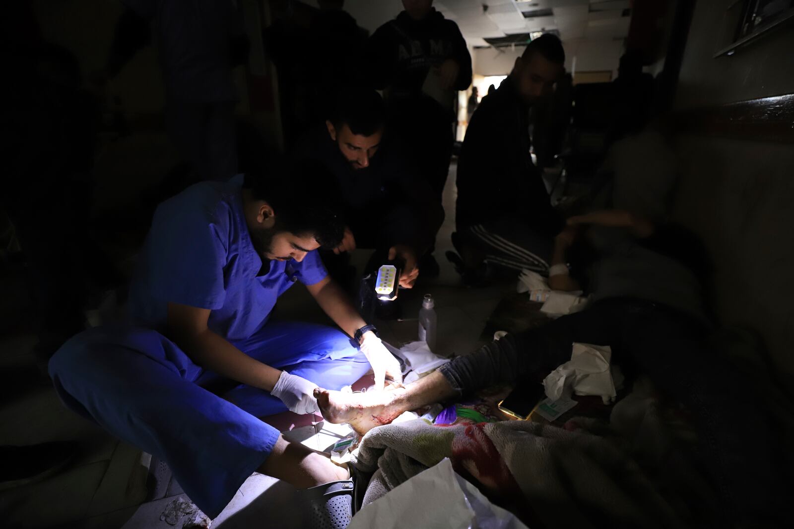 FILE - Palestinian medics treat a wounded person using torchlights after running out of power at the Indonesian hospital in Beit Lahiya during the ongoing bombardment of the northern Gaza Strip, Nov. 19, 2023. (AP Photo/Ahmed Alarini, File)