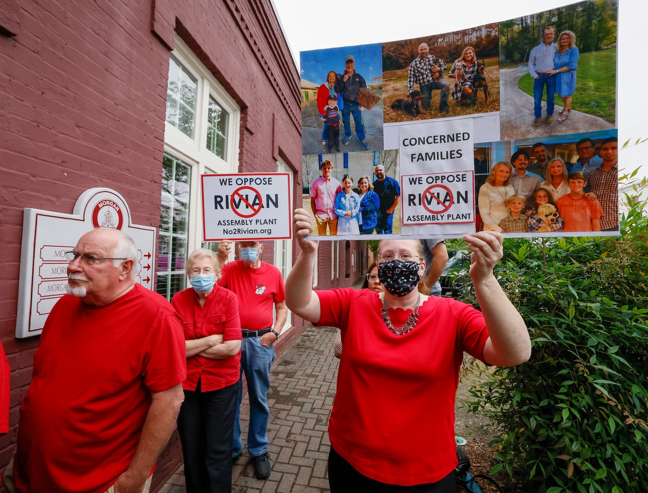 Joanie Fitzgerald (right, with sign), from Rutledge, holds a sign opposing the measure as the group gathered outside after the vote.  The Morgan County board of assessors voted to approve the Rivian tax exemption proposal in Madison on Wednesday, May 25, 2022.   (Bob Andres / robert.andres@ajc.com)