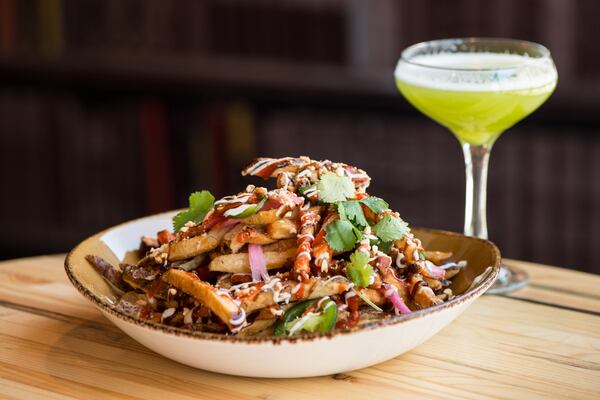  Sriracha Peanut Fries with Hoisin Sauce, Sriracha, garlic mayo, pickled chilies and red onions, crushed peanuts, and fresh cilantro. Photo credit- Mia Yakel.