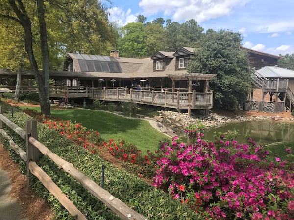 Sconyers Bar-B-Que makes its home in a massive two-story log cabin that seats 400 people. The grounds feature a pond as well as various old farm equipment. LIGAYA FIGUERAS / LFIGUERAS@AJC.COM