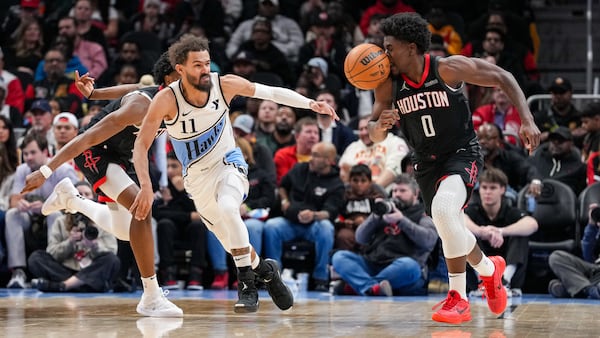 Atlanta Hawks guard Trae Young (left) chases down Houston Rockets guard Aaron Holiday on Tuesday at State Farm Arena.