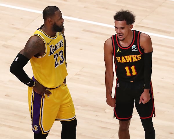 Hawks guard Trae Young and Lakers forward LeBron James share words during free throws Monday, Feb.1, 2021, at State Farm Arena in Atlanta.   (Curtis Compton / Curtis.Compton@ajc.com)