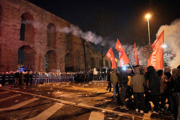 Protesters throw a flare towards anti riot police officers during a protest against the arrest of Istanbul's Mayor Ekrem Imamoglu in Istanbul, Turkey, Friday, March 21, 2025. (AP Photo/Emrah Gurel)