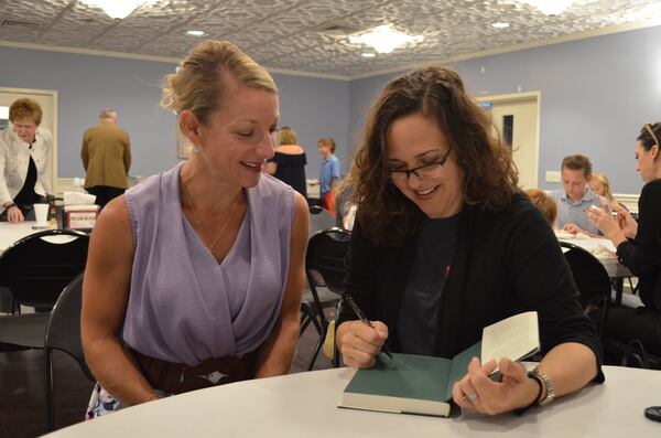 Sarah Stanley Fallaw of Marietta signs a copy of “The Next Millionaire Next Door” for a fan. Fallaw is the daughter of the late best-selling author Thomas J. Stanley. CONTRIBUTED