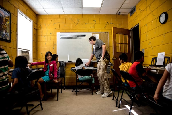 Adam Payton teaches piano to a group of children at Proskuneo, a music school in Clarkston that provides free lessons every Saturday morning on a variety of instruments for refugee children. Besides the Free for All sessions on Saturday mornings, the school offers group classes and private instruction in dance, guitar, art, piano, drums, violin and singing. BRANDEN CAMP / SPECIAL