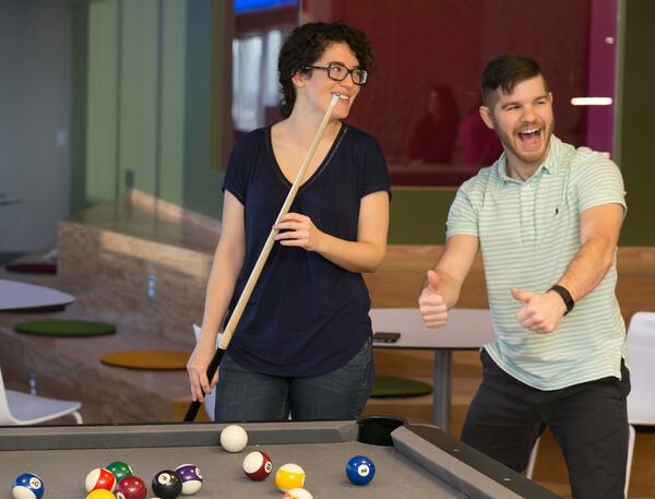 February 4, 2016-ATLANTA: Jozi Hall (left) & Andrew Hotchkiss (both cq) enjoy a game of billiards during a break at Salesforce's Atlanta office. Ping Pong, video games, a massage therapist & yoga classes help the employees enjoy their work environment. It was voted the No 1 top workplace for large companies. (Photo by Phil Skinner)