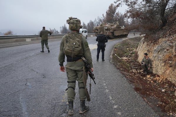 Israeli soldiers stop traffic during an alert of incoming rockets, near Kiryat Shmona, northern Israel Sunday Nov. 24, 2024. (AP Photo/Ohad Zwigenberg)