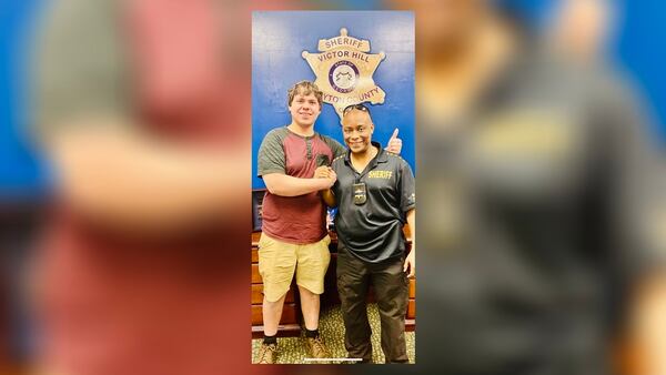 Clayton County Sheriff Victor Hill poses with Joseph Chilton, a bread delivery man who shot a robbery suspect at a Hardee's on Saturday morning. Chilton was named an “honorary deputy” by the sheriff. 