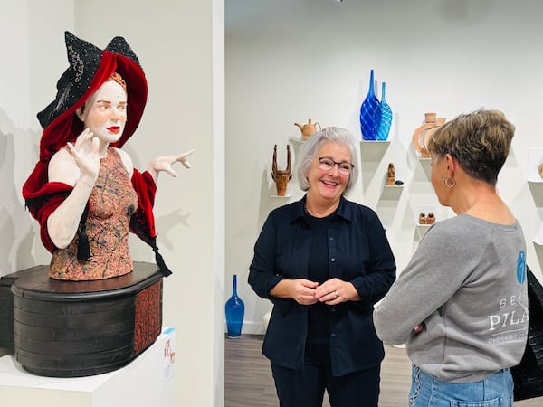 Carr McCuiston (left) and a collector Nancy Lowe Turner (right) stand near a sculpture by artist Kirsten Stingle. Turner came to Signature Contemporary Craft Gallery in November on a trip from her home in Florida to look at Stingle's unsold piece. Turner has been buying fine craft art from McCuiston for years and said she's "sad to see it go." Danielle Charbonneau/For the AJC