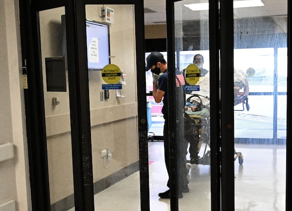 In this file photo, EMS crew bring a patient in the Emergency and Trauma Center at Northeast Georgia Medical Center (NGMC) in Gainesville in late January. Georgia is facing another surge in cases and hospitalizations. (Hyosub Shin / Hyosub.Shin@ajc.com)