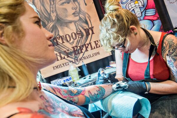 June 20, 2015 Atlanta - Emily Effler (right) works on a wrist tattoo for Glenna Kilgore during the 19th annual Atlanta Tattoo Expo at the Wyndham Atlanta Galleria hotel on Saturday, June 20, 2015. Around 100 tattoo artists from across the country were booked solid throughout the three day event as hundreds of people came out to watch and get tattooed. JONATHAN PHILLIPS / SPECIAL