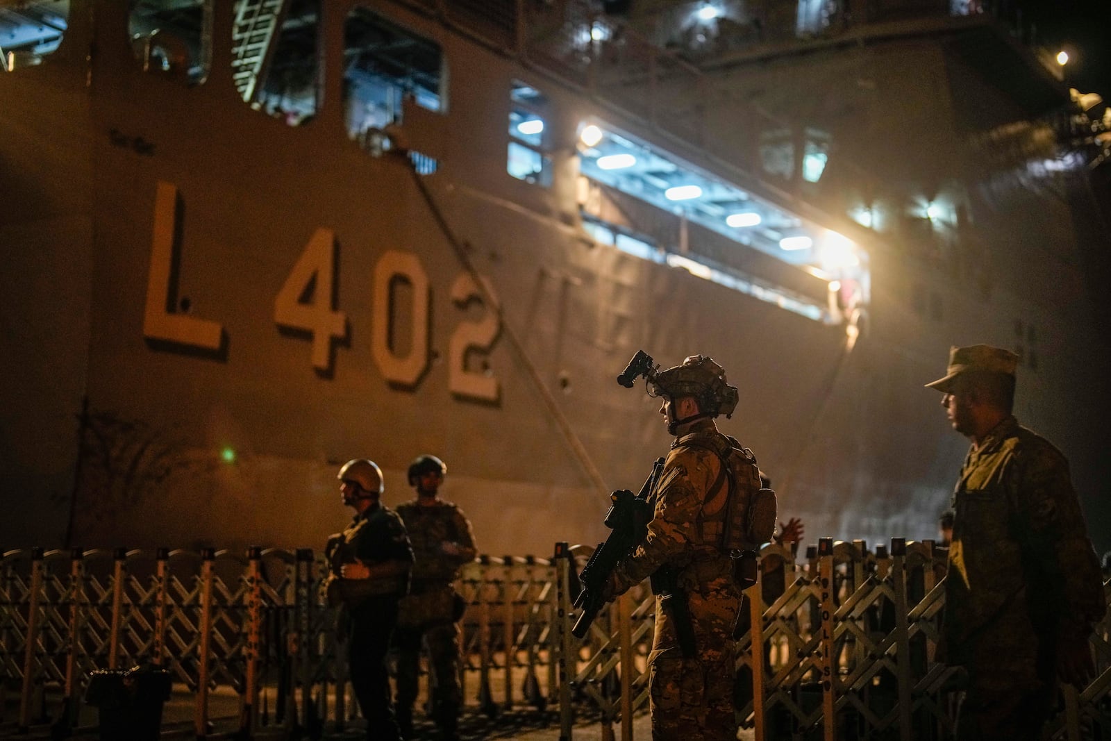 Turkish security personnel stand guard next to Turkish military ships preparing to evacuate citizens from Lebanon to Turkey in Beirut port on Wednesday, Oct. 9, 2024. (AP Photo/Emrah Gurel)