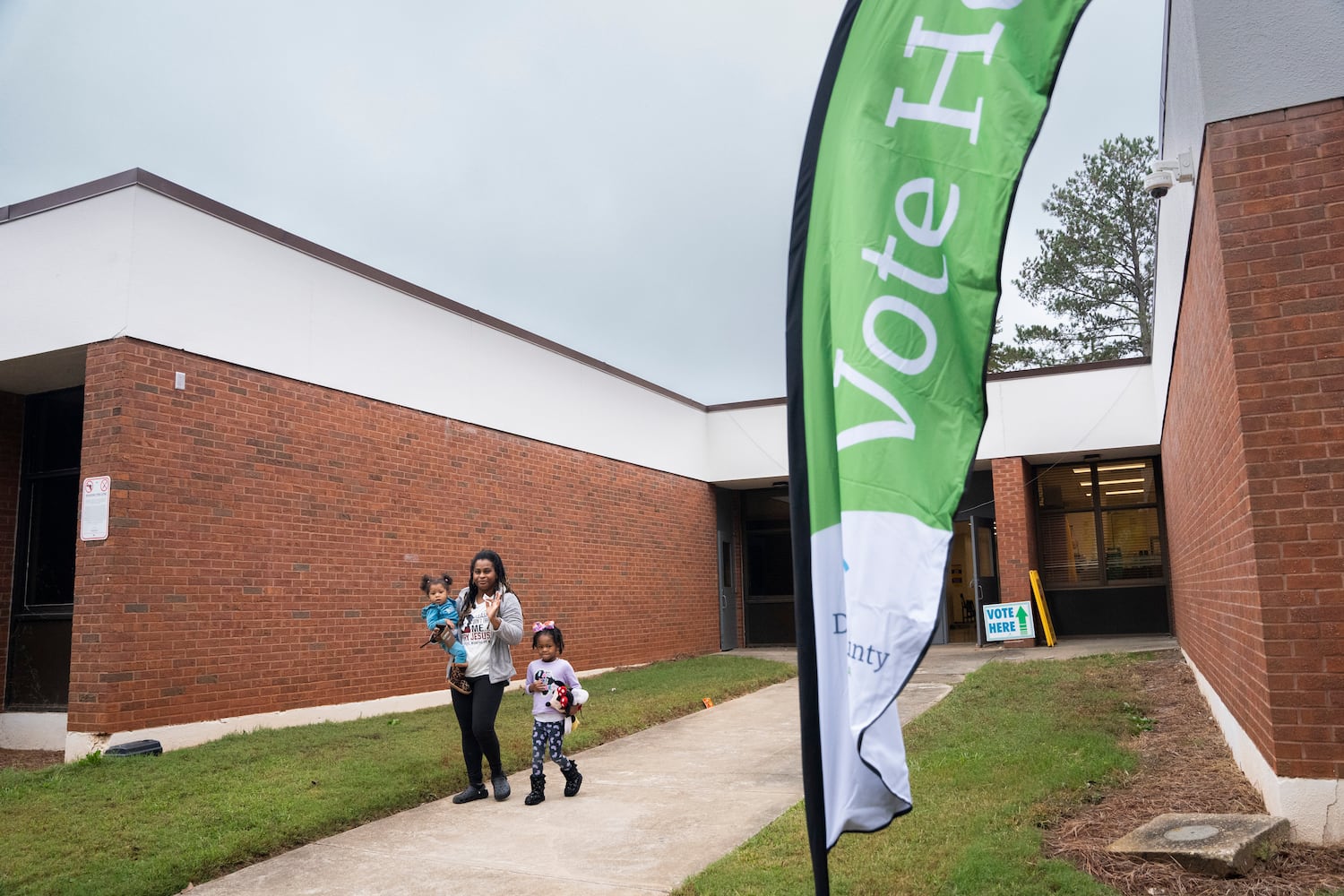 A family poses for a photo outside a polling station at Fairington Elementary in Lithonia, Georgia on Election Day, Tuesday, Nov. 5, 2024. (Olivia Bowdoin for the AJC). 