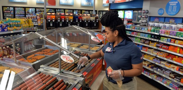 Racetrac employee Jeanique Chestnut stocks the hot food bar at a Smyrna store.  Convenience store chains, including Atlanta-base RaceTrac, are using an expanded menu of food to lure customers filling up with gas to come inside.