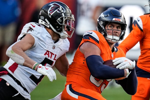 Denver Broncos linebacker Cody Barton (55) is tackled after his interception by Atlanta Falcons wide receiver Drake London (5) during the second half of an NFL football game, Sunday, Nov. 17, 2024, in Denver. (AP Photo/Jack Dempsey)