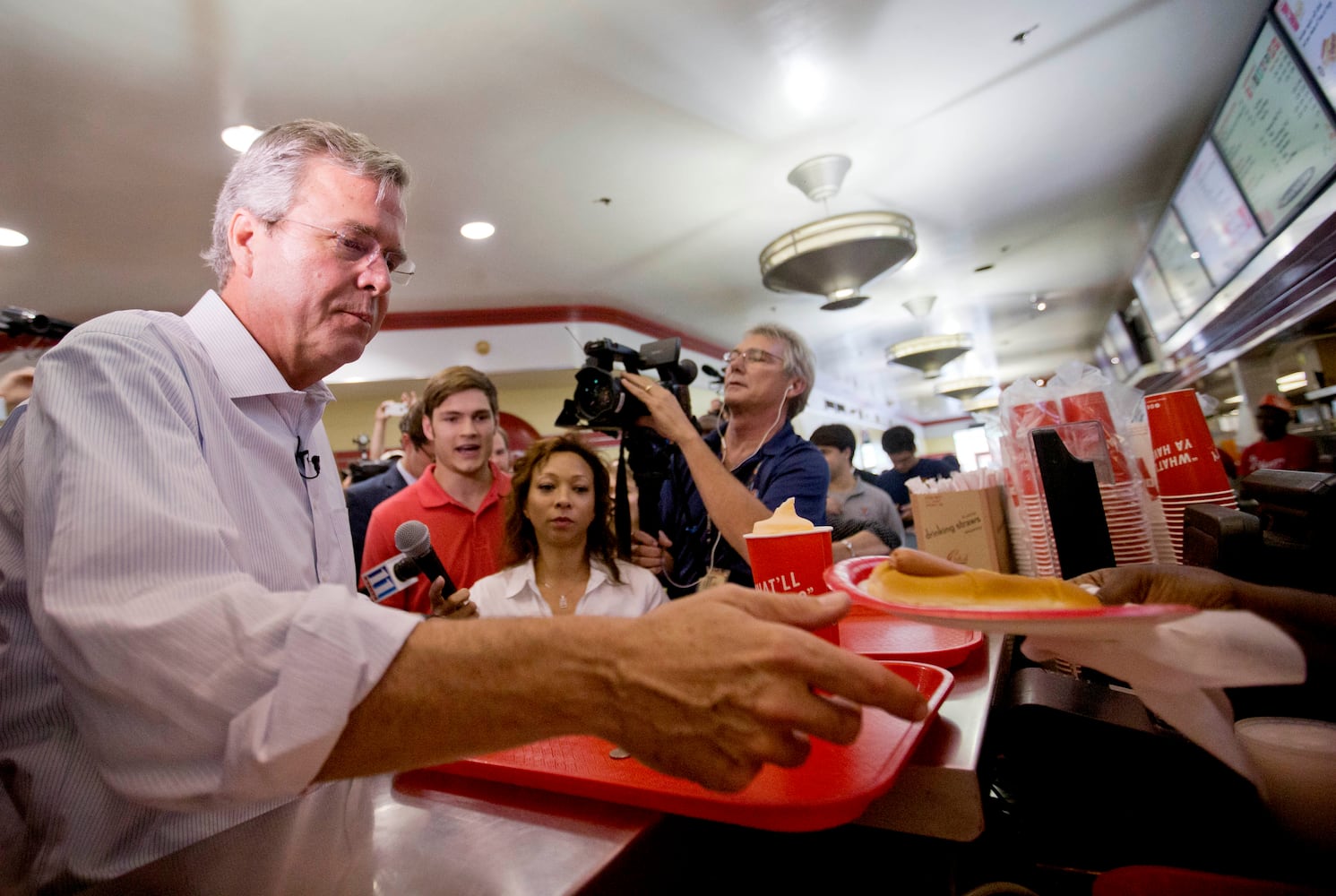 Republican presidential candidate, former Florida Gov. Jeb Bush, left, is handed a hot dog as he visits the Varsity restaurant in downtown Atlanta during a campaign stop on Tuesday. AP/David Goldman