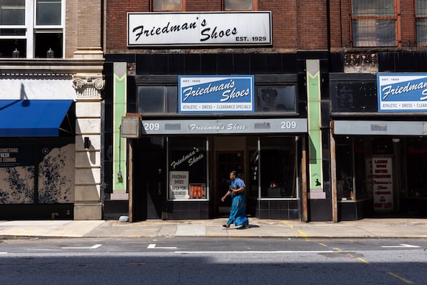 A pedestrian walks by Friedman’s Shoes in Atlanta on Wednesday, July 31, 2024. (Arvin Temkar / AJC)