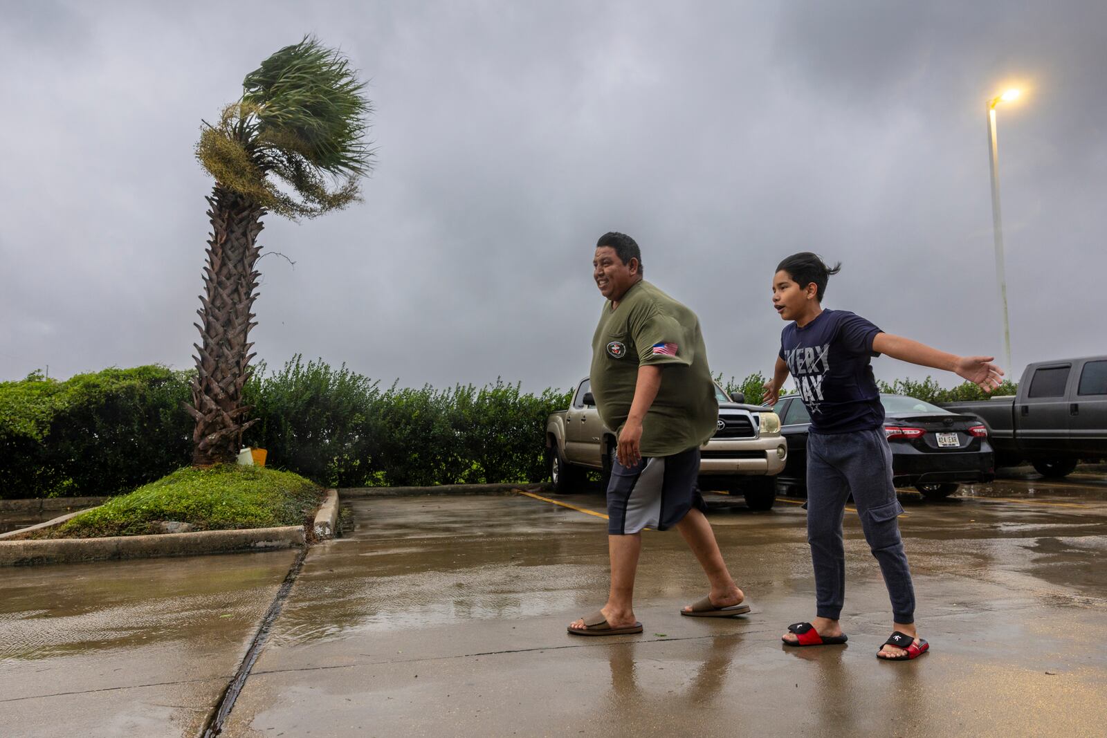 Lazaro Cardoso, 11, leans far into the powerful winds coming from the eye wall of Hurricane Francine as he and his dad, Hugo Gonzales, stay at a hotel in Houma, Louisiana that was being powered by a generator on Wednesday, Sept. 11, 2024, in Houma, La. The family lives not far from the hotel but they decided to stay at it since they said they always lose power during powerful storms. (Chris Granger/The Times-Picayune/The New Orleans Advocate via AP)