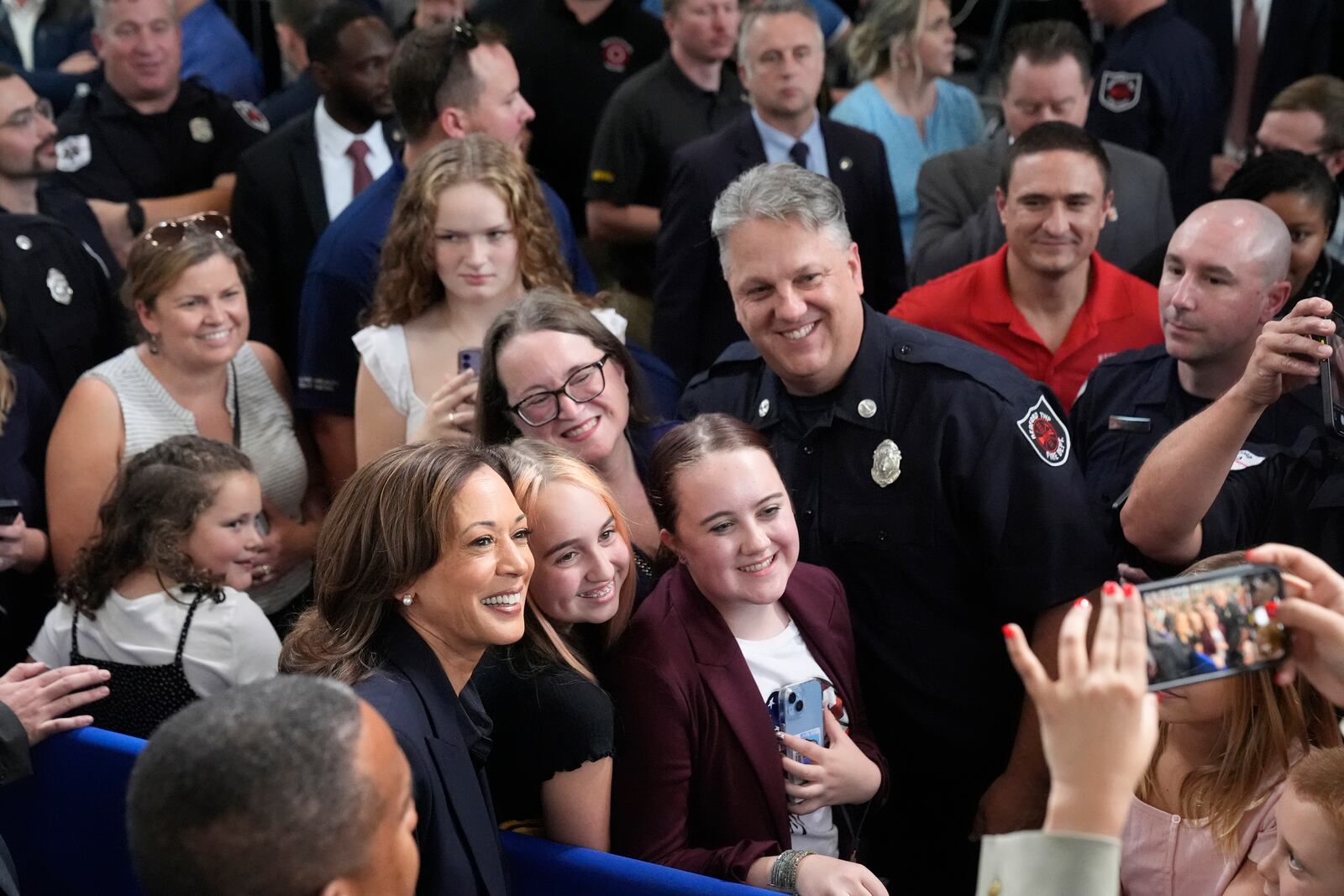 Democratic presidential nominee Vice President Kamala Harris, in foreground at left, takes a photo with attendees after speaking during an event at the Redford Township Fire Department North Station in Redford Township, Mich., Friday, Oct. 4, 2024. (AP Photo/Mark Schiefelbein)