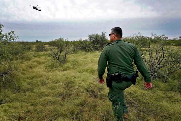 U.S. Border Patrol agent Jesus Vasavilbaso, aided by a Black Hawk helicopter, searches for a group of migrants evading capture in the desert brush at the base of the Baboquivari Mountains, Thursday, Sept. 8, 2022, near Sasabe, Ariz. (AP Photo/Matt York, File)