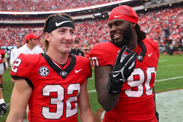 Georgia running back Cash Jones (32) and defensive lineman Tramel Walthour (90) celebrate their 24-14 win against South Carolina at Sanford Stadium, Saturday, September 16, 2023, in Athens, Ga. (Jason Getz / Jason.Getz@ajc.com)