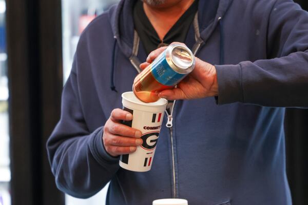 A concession employee pours a beer into a cup for a Georgia fan before Georgia’s men’s basketball game against Alabama at Stegemen Coliseum, Wednesday, January 31, 2024, in Athens, Ga. (Jason Getz / jason.getz@ajc.com)