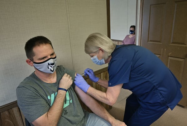 January 27, 2021 Elberton - Elbert County High School teacher Richard Andrews receives his second dose of the COVID-19 vaccine from Tina Mewborne, LPN, as his wife and teacher Tonya Andrews (background) looks at the Medical Center of Elberton on Wednesday, January 27, 2021. Georgia has not opened COVID-19 vaccination to teachers yet, but a small school district east of Athens still managed to offer shots to any employee who wanted them. Elbert County Superintendent Jon Jarvis told The Atlanta Journal-Constitution that he sees his teachers, bus drivers and other employees as essential personnel who should be prioritized for vaccination. The state didn't see it that way, punishing the medical center by suspending vaccine shipments until July 27. (Hyosub Shin / Hyosub.Shin@ajc.com)