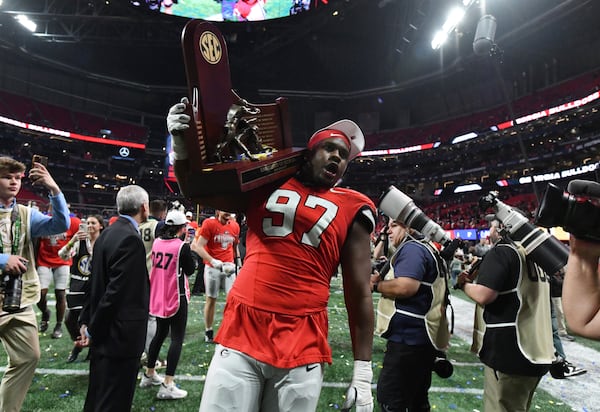 Georgia players celebrate victory over Texas in overtime during the SEC Championship football game at the Mercedes-Benz Stadium, Saturday, December 7, 2024, in Atlanta. Georgia won 22-19 over Texas in overtime. (Hyosub Shin / AJC)