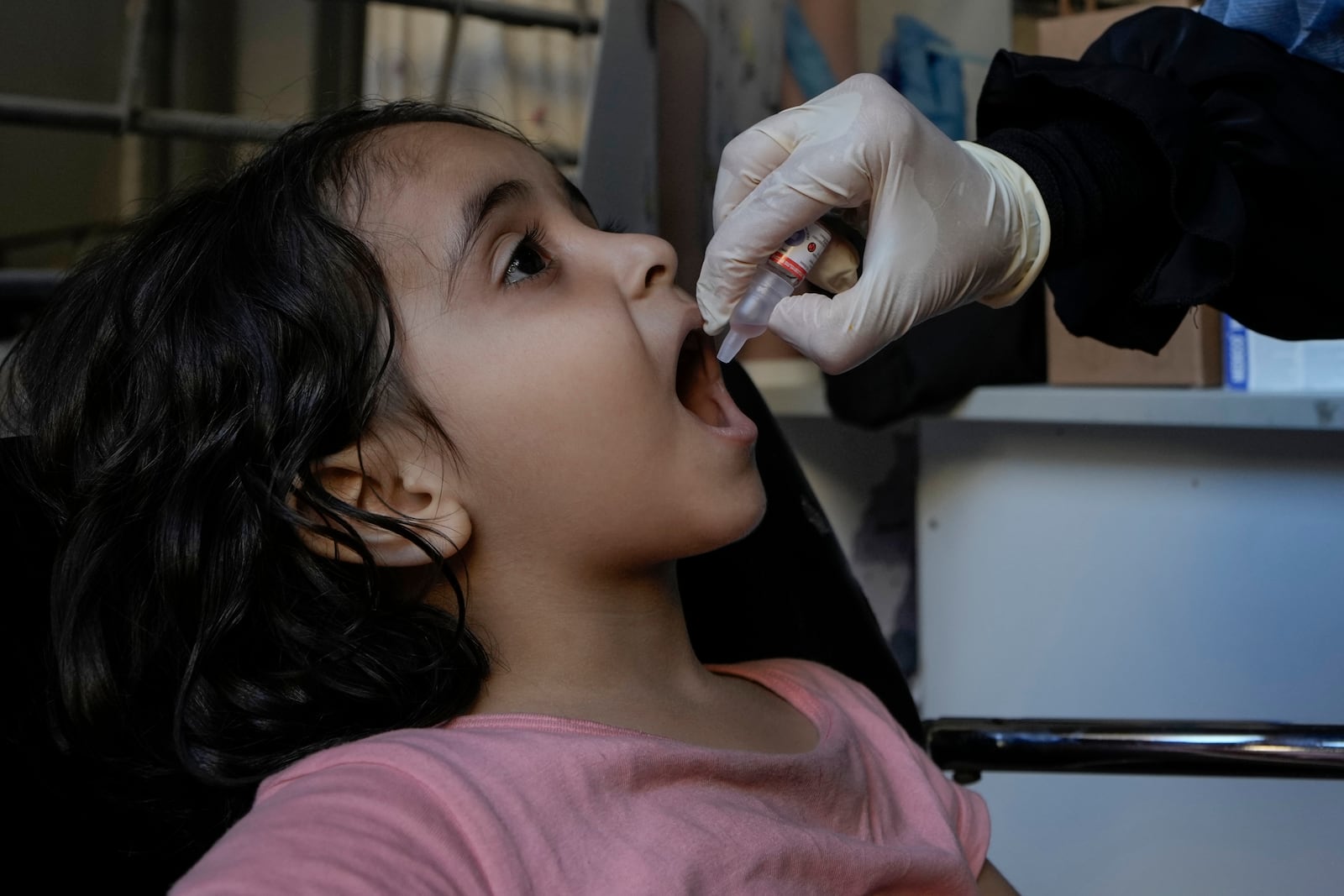 Angelina, who is fleeing the Israeli airstrikes with her family from Dahiyeh, receives a polio vaccine in an empty building complex, in Beirut, Lebanon, Wednesday, Oct. 9, 2024. (AP Photo/Bilal Hussein)