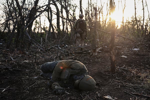 FILE - A Ukrainian assault unit commander passes by a dead Russian soldier on the front line near Andriivka, Ukraine, Saturday, Sept. 16, 2023. (AP Photo/Alex Babenko, File)