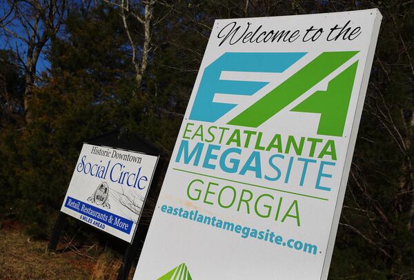 An East Atlanta Megasite sign marking the Rivian project site sits next to a historic downtown Social Circle sign at the Stanton Springs exit in Newton County at I-20 on Tuesday, Jan. 18, 2022, in Social Circle.   “Curtis Compton / Curtis.Compton@ajc.com”`