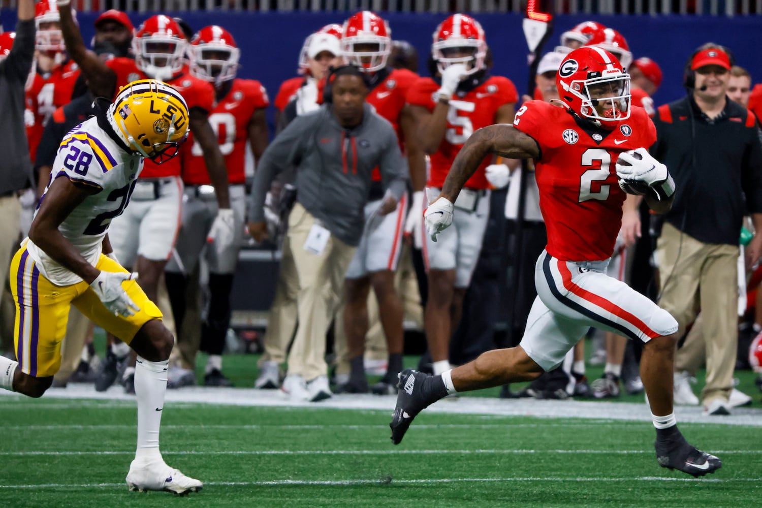 Georgia Bulldogs running back Kendall Milton (2) runs past LSU Tigers safety Major Burns (28) during the second half of the SEC Championship Game at Mercedes-Benz Stadium in Atlanta on Saturday, Dec. 3, 2022. (Bob Andres / Bob Andres for the Atlanta Constitution)