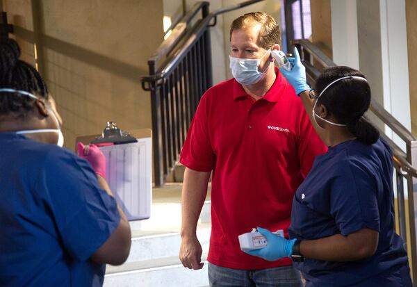 CVS employee Jim Crispyn gets his temperature checked during check-in in preparation for the opening of the COVID-19 drive-through testing center in Atlanta, April 6, 2020.  STEVE SCHAEFER / SPECIAL TO THE AJC