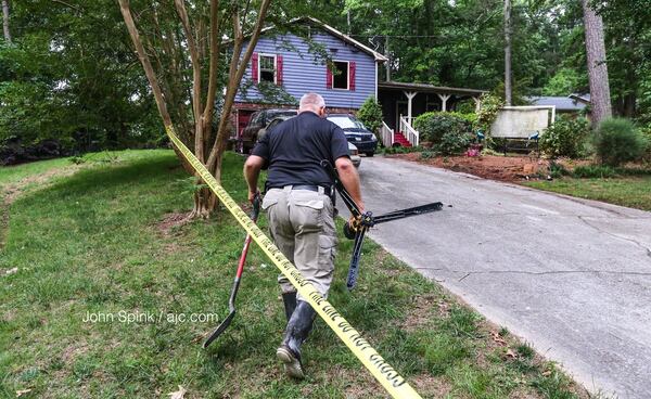 Douglas County fire investigator S. Pate was on the scene Tuesday morning following a house fire that killed a 10-year-old boy and the child’s adult cousin. The cause of the fire has not been determined. JOHN SPINK / JSPINK@AJC.COM