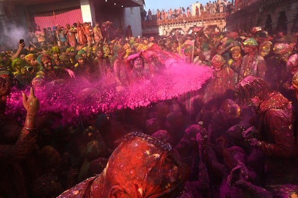 Villagers from Barsana and Nandgaon smeared with colors participate in Lathmar Holi at Nandagram temple in Nandgoan village, 115 kilometers (70 miles) south of New Delhi, India, Sunday, March 9, 2025. (AP Photo)