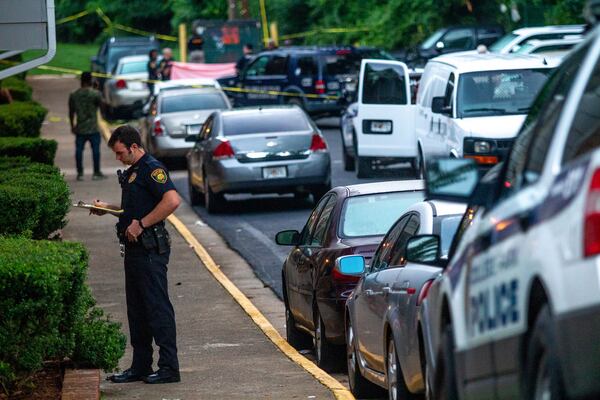 A College Park police officer talks to residents of The Life at Avery Park apartments after an early morning shooting that left one man dead and a woman in critical condition Monday, June 24, 2019.  STEVE SCHAEFER / SPECIAL TO THE AJC