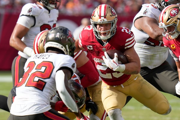 San Francisco 49ers running back Christian McCaffrey, right, runs against Tampa Bay Buccaneers safety Josh Hayes (32) during the second half of an NFL football game in Tampa, Fla., Sunday, Nov. 10, 2024. (AP Photo/Chris O'Meara)