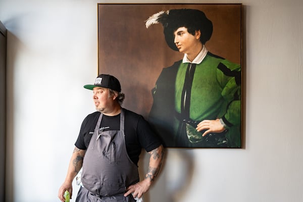 Terry Koval stands next to a painting that his wife, Jenn Koval, acquired for the sitting area of Fawn, their new amaro and wine bar in Decatur.
(Courtesy of Morgan Wagoner)