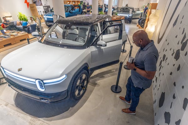  Rivian employee Russ Mooney looks over the new R2 prototype that will eventually be made in Georgia at the Ponce City Market in Atlanta on April 27, 2024. (Steve Schaefer / AJC)