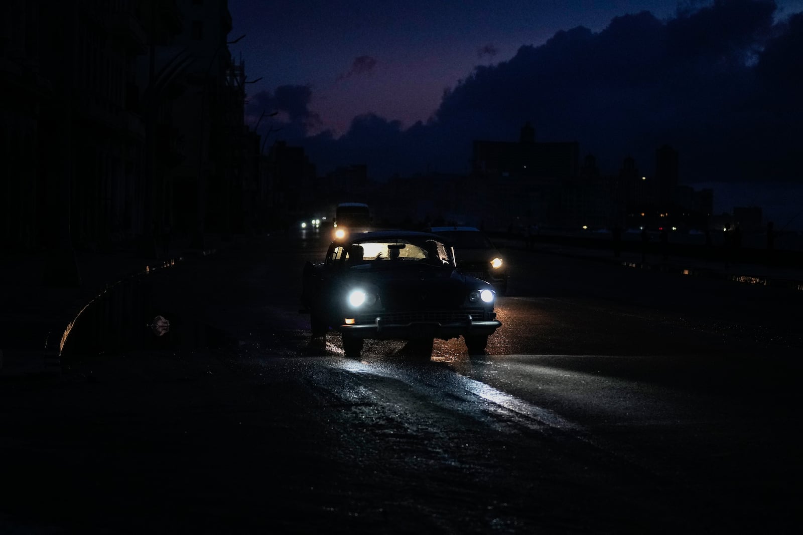 Vehicles make their way along the Malecon during a massive blackout after a major power plant failed in Havana, Cuba, Friday, Oct. 18, 2024. (AP Photo/Ramon Espinosa)