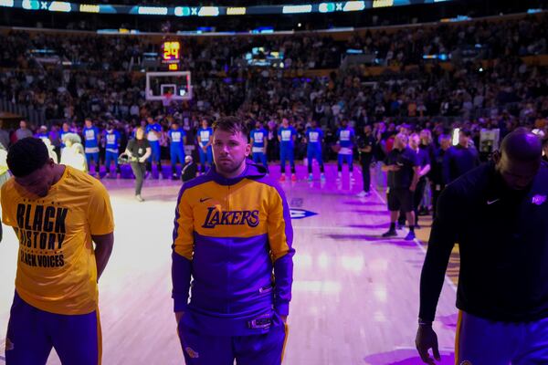 Los Angeles Lakers guard Luka Doncic, center, listens to the national anthem before an NBA basketball game against the Dallas Mavericks, Tuesday, Feb. 25, 2025, in Los Angeles. (AP Photo/Mark J. Terrill)