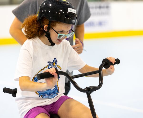 Special needs camper Nicole, was all smiles as she learned how to ride a two-wheel bike with adaptations. PHIL SKINNER FOR THE ATLANTA JOURNAL-CONSTITUTION.