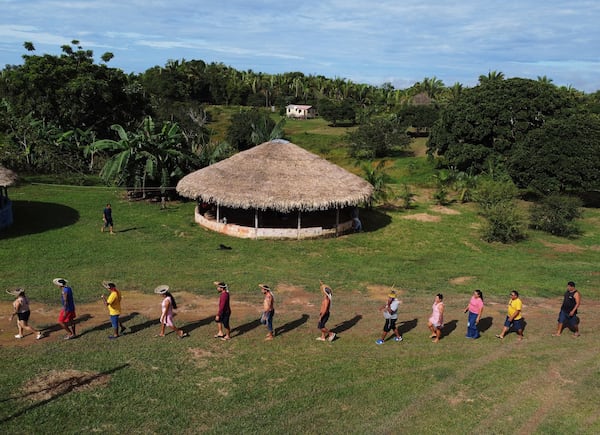 Members of the Mura Indigenous community walk to participate in a gathering of leaders, in the Moyray village, in Autazes, Amazonas state, Brazil, Friday, Feb. 21, 2025. (AP Photo/Edmar Barros)