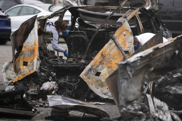 ATF investigators inspect burned Tesla Cybertrucks at a Tesla lot in Seattle, Monday, March 10, 2025. (AP Photo/Lindsey Wasson)