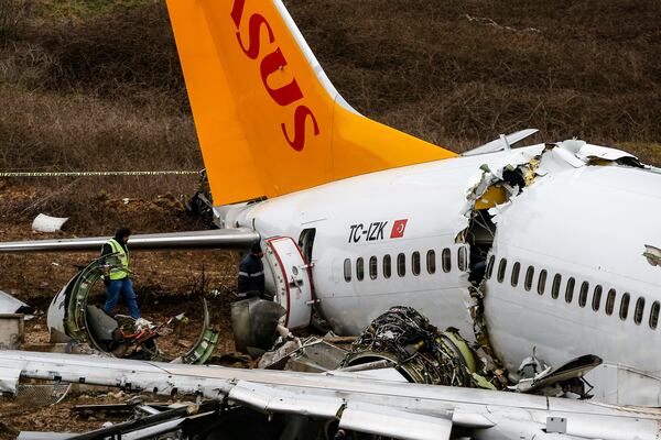 Officials work on the wreckage of a plane operated by Pegasus Airlines.