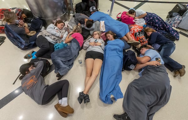 FFA and 4H members from Daytona, Florida sleep after arriving from judging livestock in Stillwater, Oklahoma, with no flight to Florida on Friday, July 19, 2024 at the Hartsfield-Jackson Airport. (John Spink/AJC)