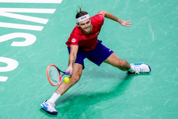 Taylor Fritz of the United States returns the ball to Australia's Alex de Minaur during a Davis Cup quarterfinal match at the Martin Carpena Sports Hall, in Malaga, southern Spain, on Thursday, Nov. 21, 2024. (AP Photo/Manu Fernandez)